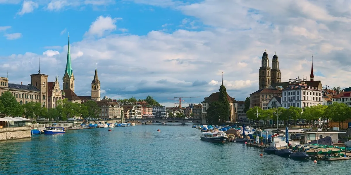 Zurich's old town from the Quaibrücke: boats on the River Limmat below the spires of the Fraumünster and St Peter and the twin towers of the Grossmünster